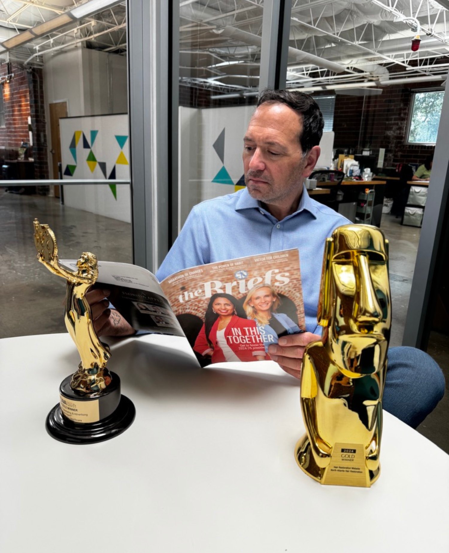 Marc Apple with gold award trophies for law firm marketing and advertising